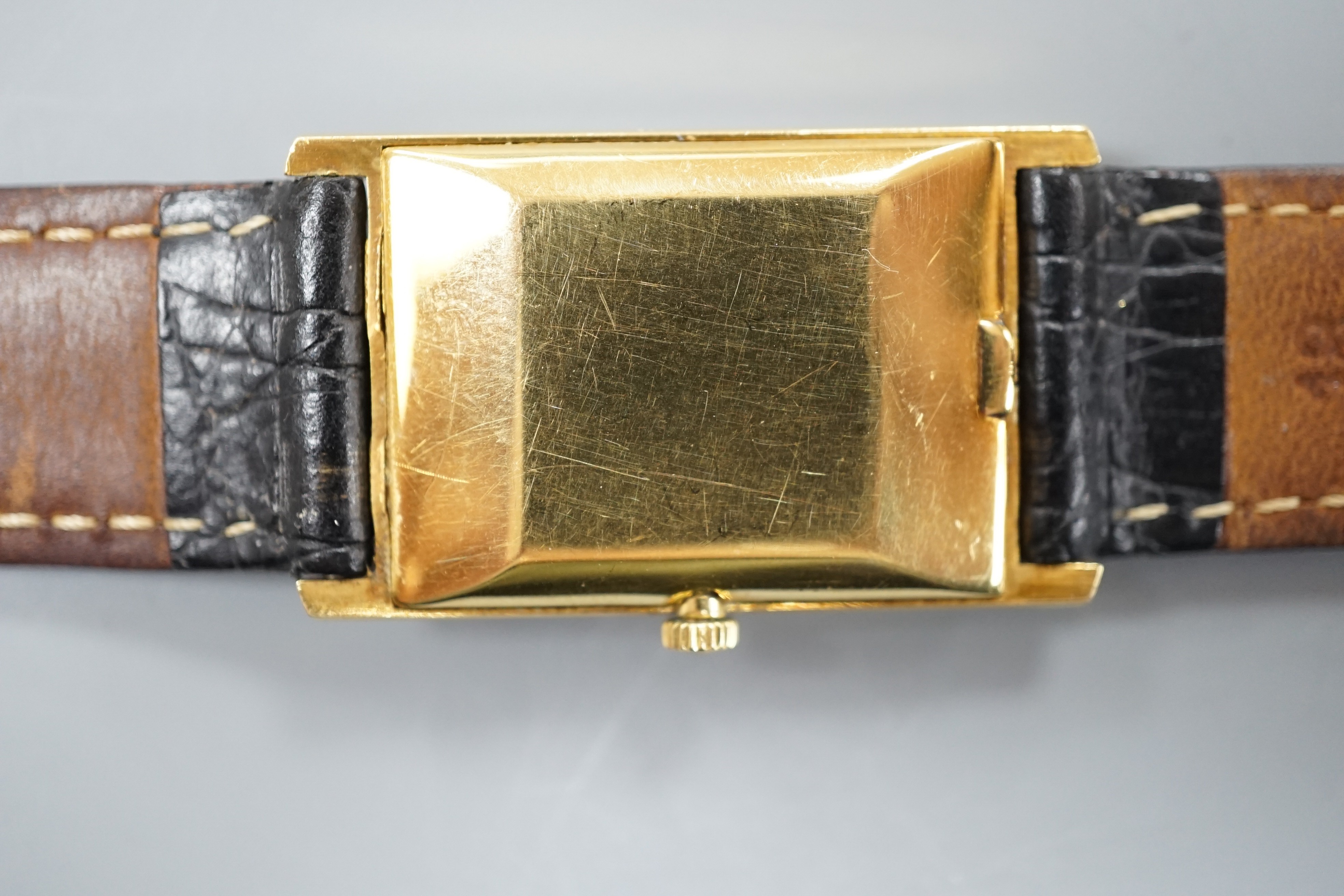 A gentleman's 750 yellow metal Ebel rectangular dial manual wind wrist watch, on associated leather strap, case diameter 22mm, gross weight 24.3 grams.